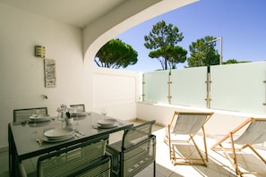 A dining area with a table set for two, chairs, and a view of trees and sky. - FLH Vale do Lobo Delightful Terrace (Vale do Lobo)