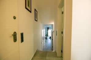 A hallway with a door on the right, a light switch on the left, and a framed picture on the wall. - FLH Vale do Lobo Delightful Terrace (Vale do Lobo)