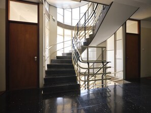 A spiral staircase with metal railings and a black marble floor. - FLH Boavista: Stylish Apartment with a View (Porto)