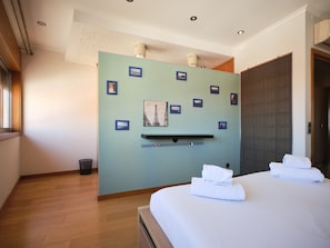 A hotel room with a bed, a wall-mounted shelf, and a door. - FLH Porto Central Comfy Duplex (Porto)