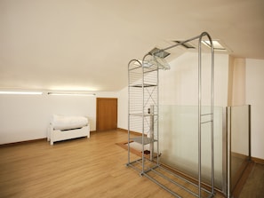 A room with a white bed, a metal shelving unit, and a glass partition. - FLH Porto Central Comfy Duplex (Porto)