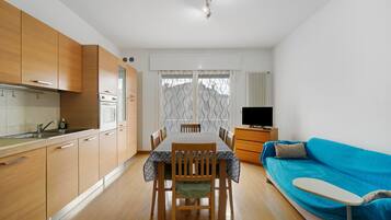 A compact living space with a kitchenette, dining area, and a sofa.