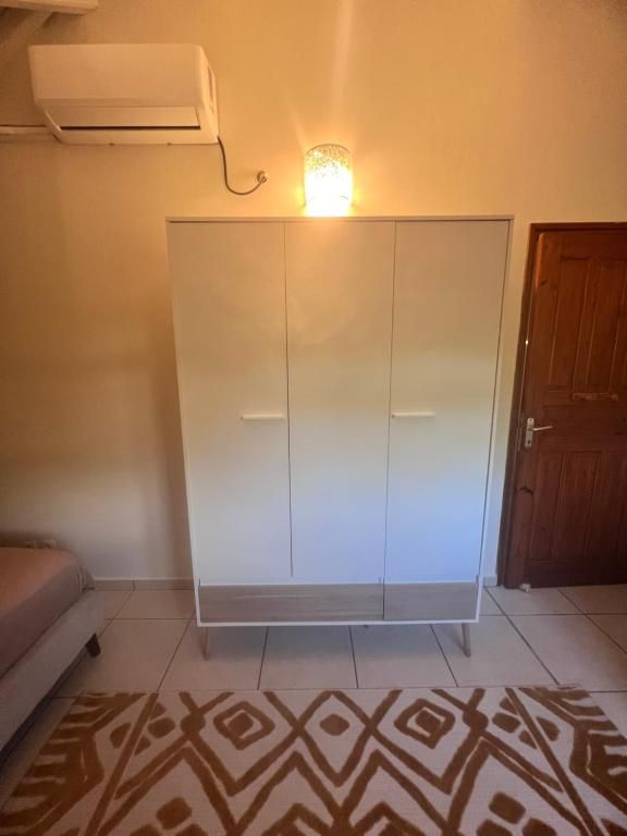 A room with a wardrobe, a patterned rug, and a door.