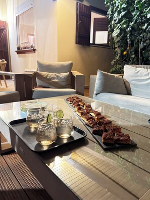 A modern living room with a glass coffee table, a sofa, and a chair.