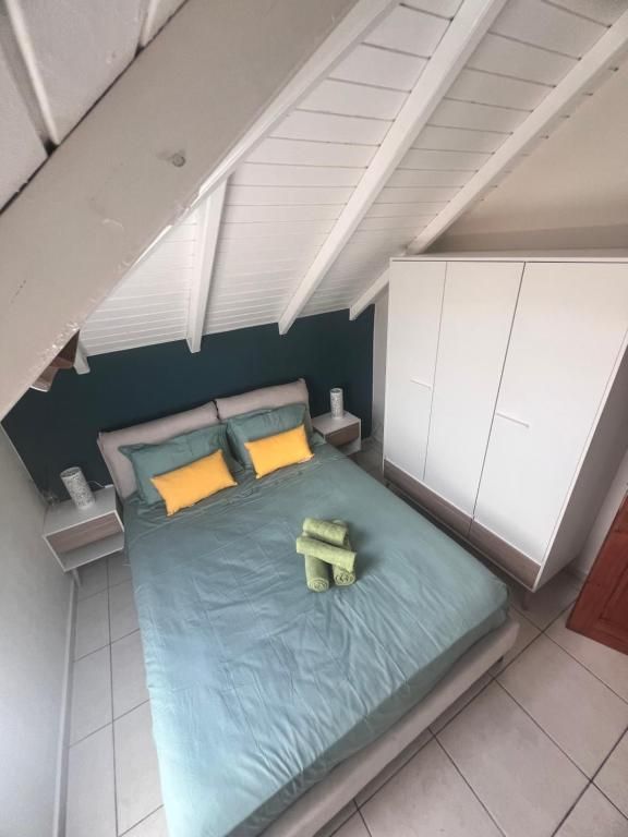 A bedroom with a bed, nightstands, a wardrobe, and a sloped ceiling.