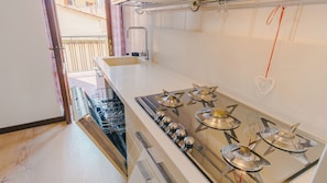 A kitchen with a gas stove, a dishwasher, and a sink. - Veronetta Living - Two Bedroom Apartment, Sleeps 5 (Verona)