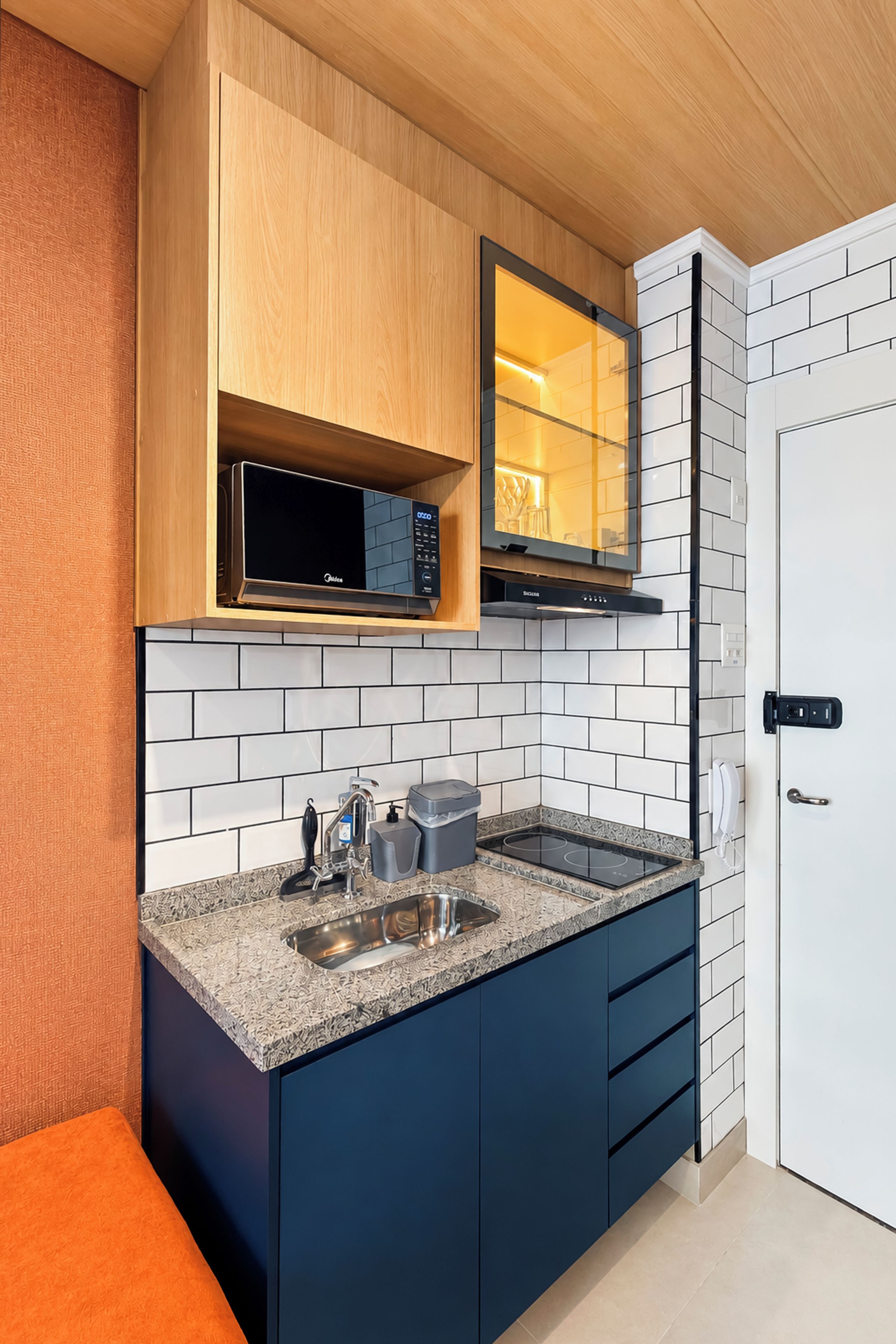 A modern kitchen with a built-in microwave, a sink, and a stove.
