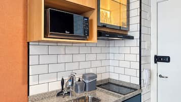 A modern kitchen with a built-in microwave, a sink, and a stove.