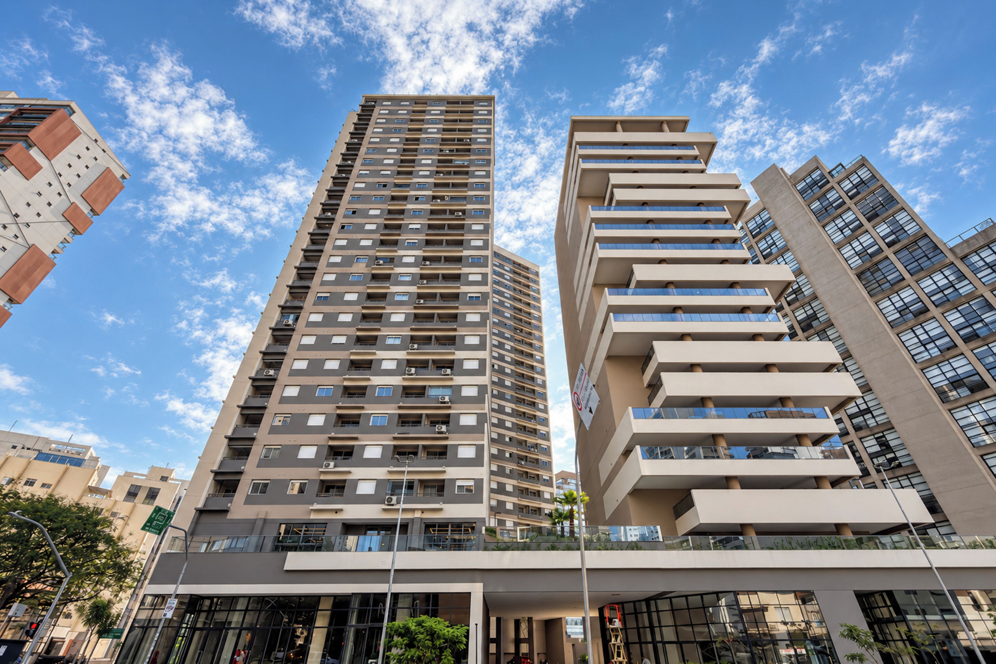 A modern high-rise building with multiple balconies and a clear sky.