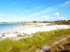 A beach with white sand, scattered rocks, and a clear blue sky. - Comfortable chalet 150m from Grève Blanche beach (Plouguerneau)