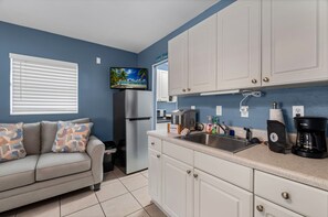 A kitchenette with a refrigerator, microwave, coffee maker, and sink. - Fisherman's Studio: Unit 1 (studio only) (Satsuma)