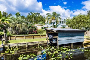 A waterfront property with a dock, a small shed, and a house in the background. - Fisherman's Studio: Unit 1 (studio only) (Satsuma)
