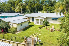 A residential area with multiple houses, a fenced yard, and a wooden deck. - Fisherman's Studio: Unit 1 (studio only) (Satsuma)