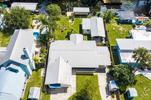 A residential area with multiple houses, a central building with a unique roof design, and a small pond with lily pads. - Fisherman's Studio: Unit 1 (studio only) (Satsuma)