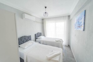 A hotel room with two beds, a ceiling light, and a painting on the wall. - Villa Dogakent 4 - Four Bedroom Villa, Sleeps 8 (Okçular)