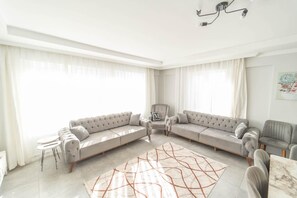 A spacious living room with a large sectional sofa, a small table, and a decorative rug. - Villa Dogakent 4 - Four Bedroom Villa, Sleeps 8 (Okçular)