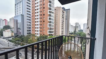 Ein Balkon mit Blick auf eine Stadtansicht, der moderne Gebäude und eine Straße darunter zeigt.