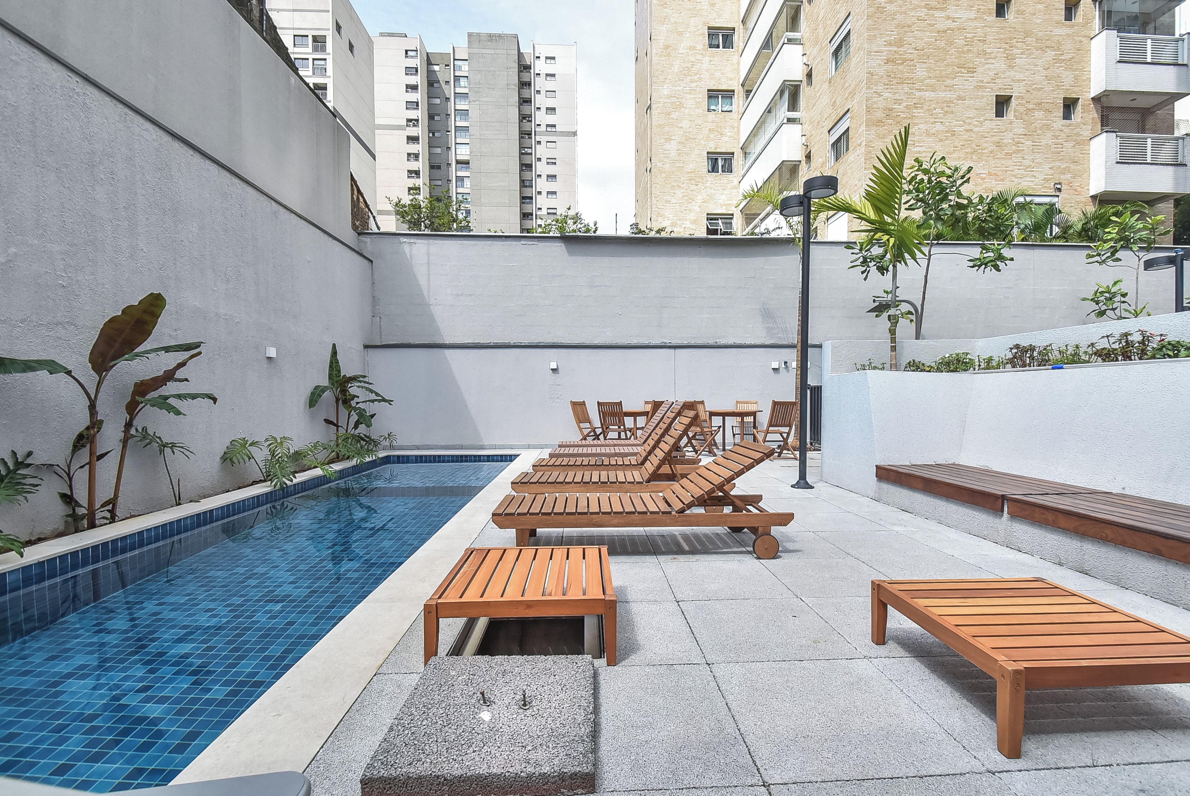 A rooftop pool area with lounge chairs and a small pool.