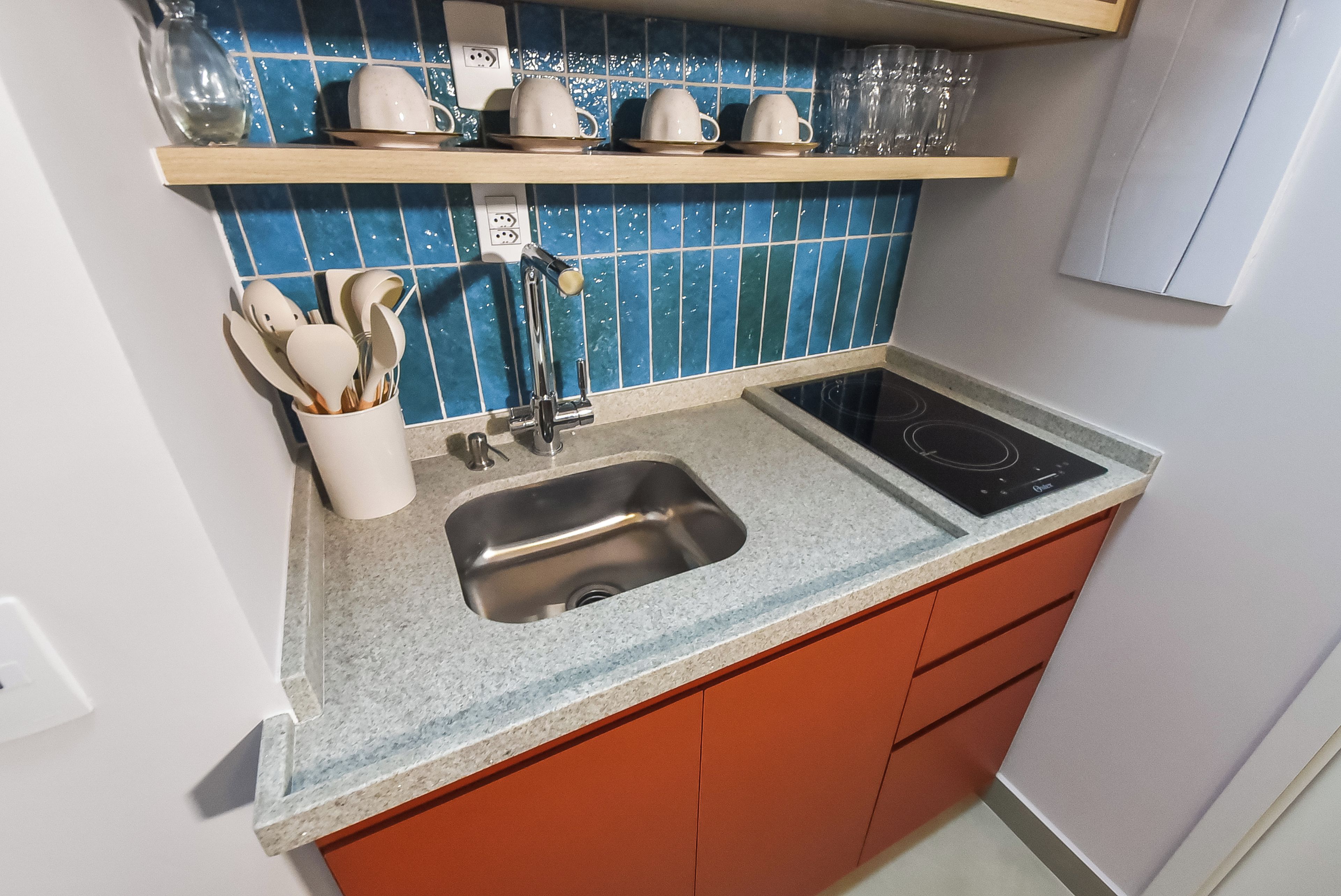 A kitchen with a double sink, a stove, and a utensil holder.