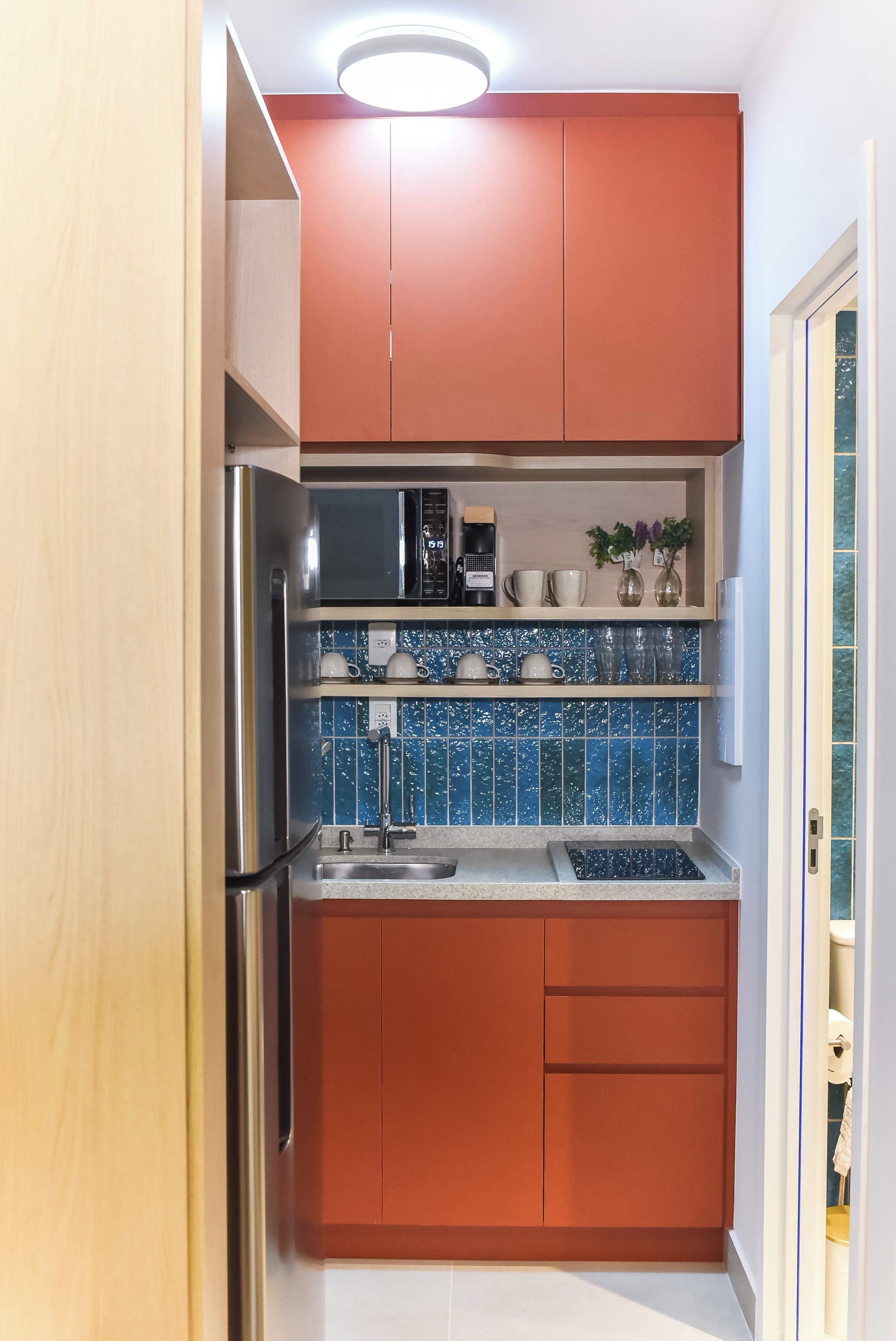 A compact kitchen with a refrigerator, microwave, and a coffee maker on the countertop.