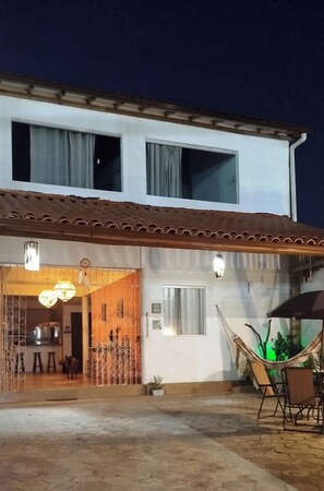 A two-story building with a covered patio area. - Casa Amigos do Arraial (Porto Seguro)