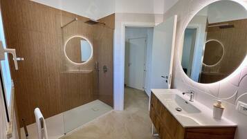 A modern bathroom with a shower, toilet, and vanity.