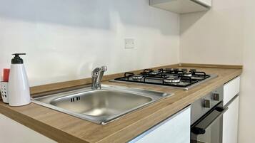 A modern kitchen with a stainless steel sink, a gas stove, and wooden countertops.