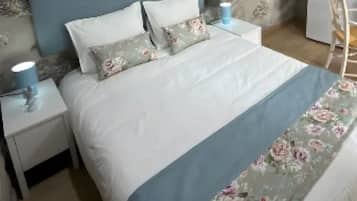 A bedroom with a bed, nightstands, a lamp, a chair, and a dresser.