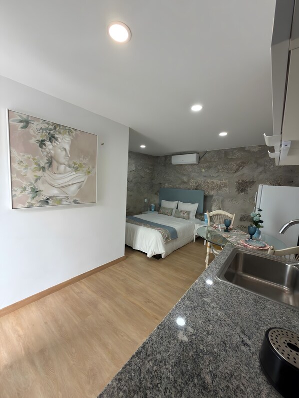 Une chambre à coucher moderne avec un lit, une table de chevet et un tableau.