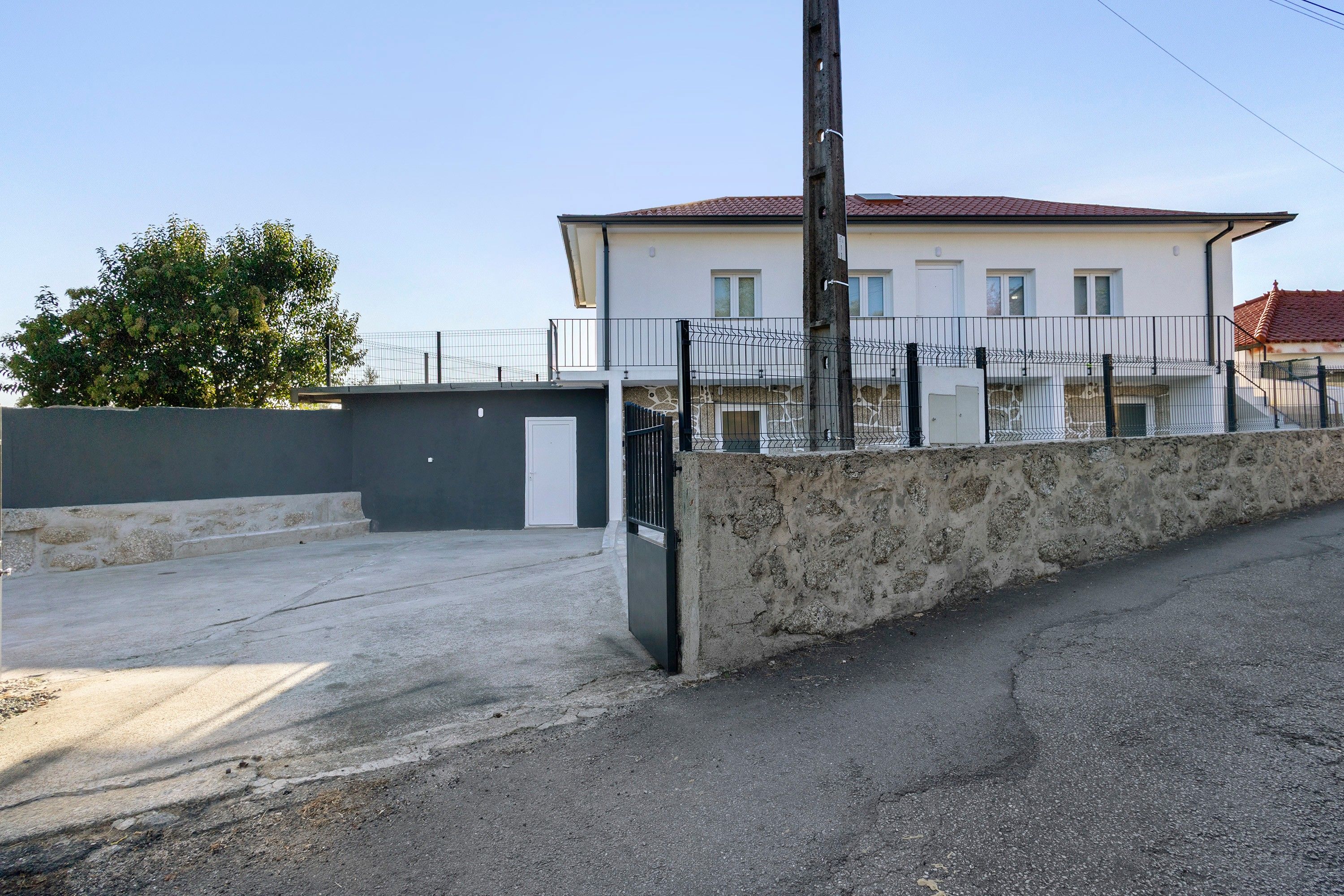 Un bâtiment à deux étages, doté d’une façade blanche et d’un toit recouvert de tuiles rouges.