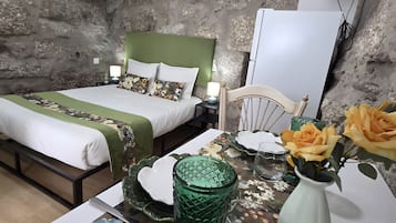 A hotel room with a bed, bedside table, and a chair.