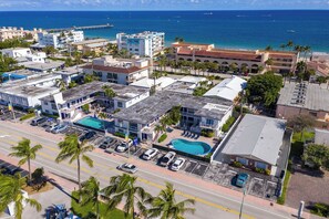 An aerial view of a coastal hotel with a swimming pool, parking area, and ocean view. - Comfy 1 Bed 1 Bath Apt Minutes to the Beach, Pool (Lauderdale-by-the-Sea)
