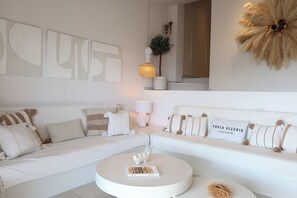 A modern living room with a white sofa, a round coffee table, and decorative pillows. - U Mulinu | Villa with Ocean Views | Panorama Santa Giulia (Porto-Vecchio)