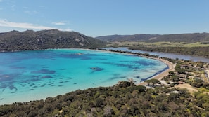 A coastal area with a clear turquoise sea, a sandy beach, and a forested hill. - U Mulinu | Villa with Ocean Views | Panorama Santa Giulia (Porto-Vecchio)