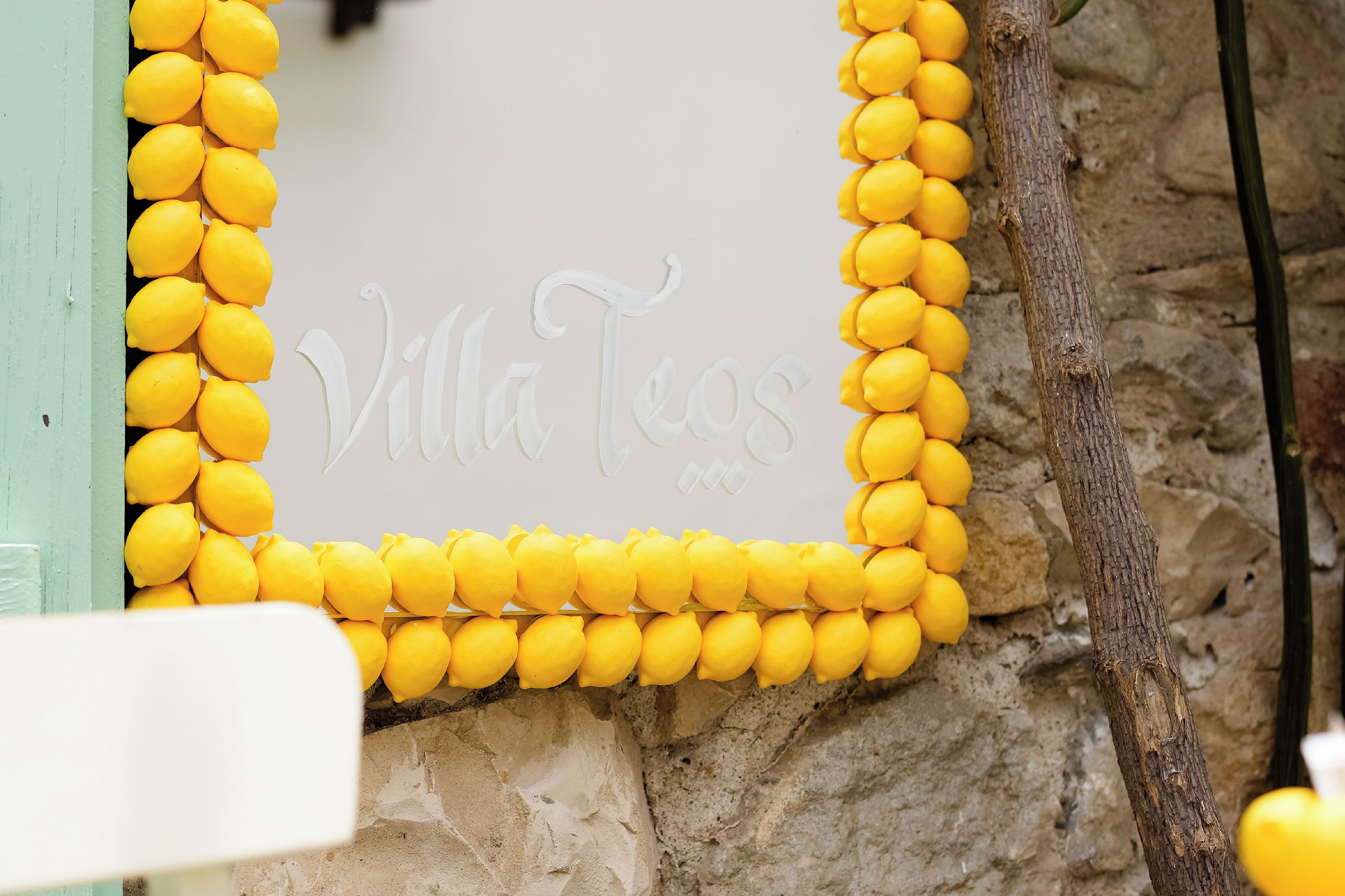 A wall with a decorative border made of yellow lemons and the inscription 'Villa Teos'.