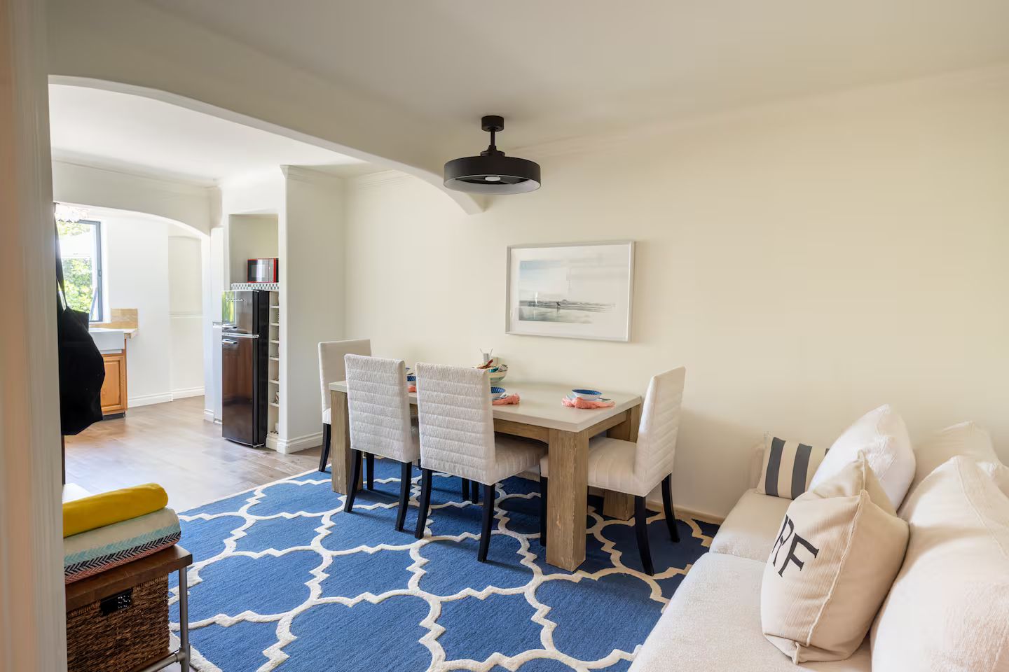 A dining area with a table, chairs, and a ceiling light.