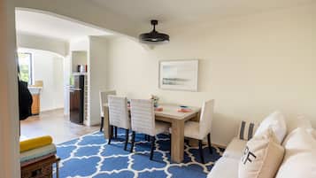 A dining area with a table, chairs, and a ceiling light.