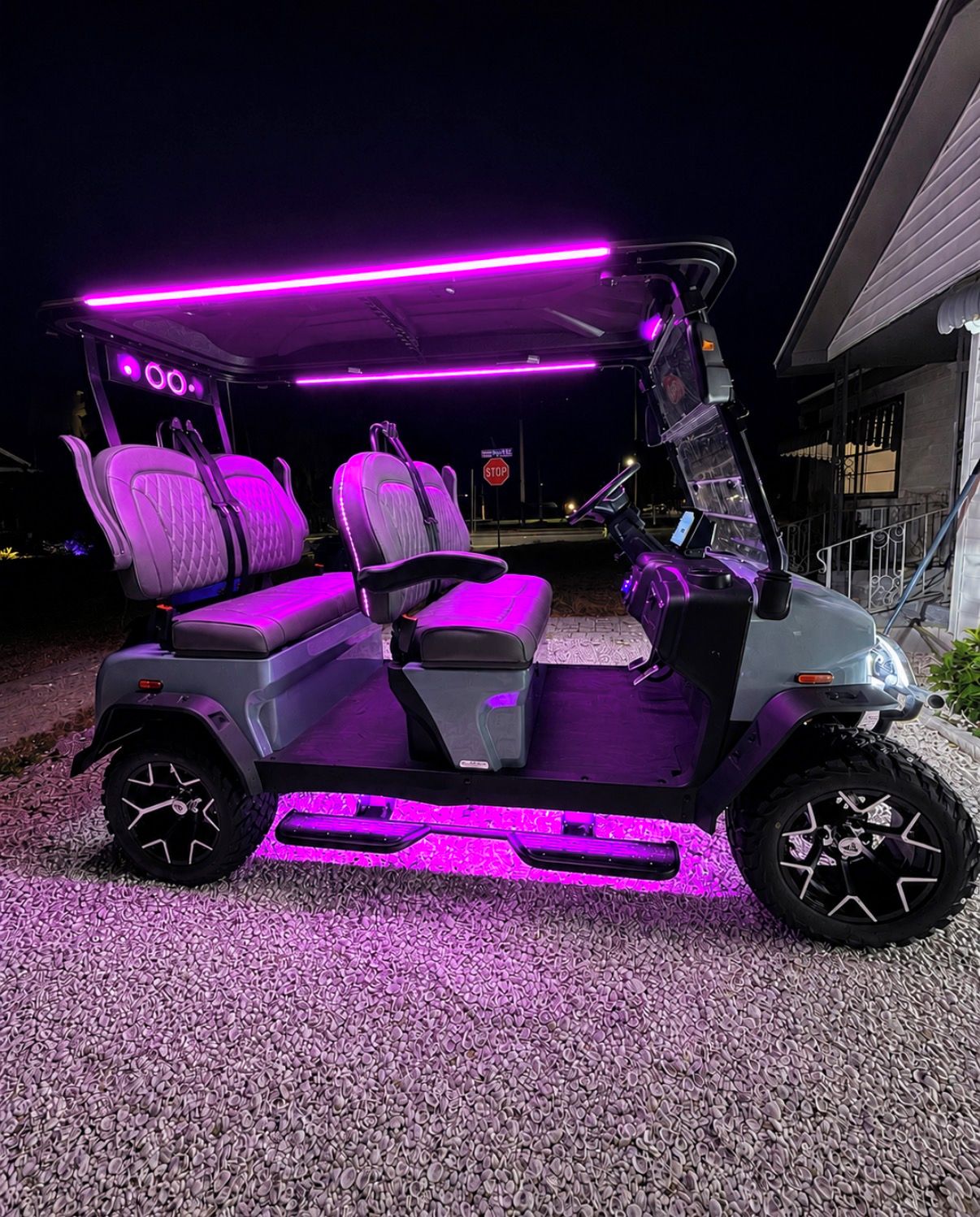 A golf cart with purple LED lighting on the seats and undercarriage.