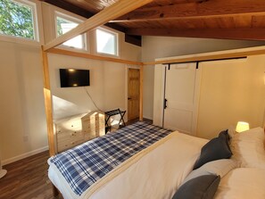 A bedroom with a bed, a TV mounted on the wall, a wardrobe, and a window. - China Lake Chalet with Private Waterfront & Dock (China)