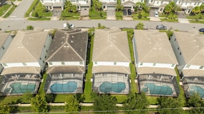 A residential area with multiple houses featuring pitched roofs and swimming pools. - The best 9-suite house at Sonoma Resort (Kissimmee)