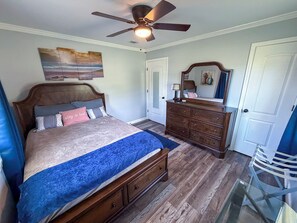 A bedroom with a bed, dresser, mirror, ceiling fan, and artwork on the wall. - Livingston Retreat w/ Covered Patio & Yard (Livingston)