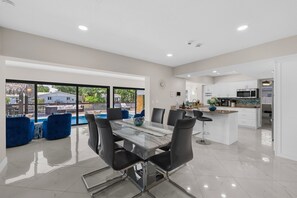 A modern kitchen with white cabinets, a stainless steel microwave, and a granite countertop. - Pelican Point Waterfront Heated Pool Tiki (Plantation)
