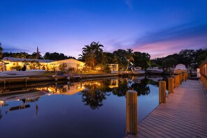 A waterfront property with a dock, boats, and a wooden walkway. - Pelican Point Waterfront Heated Pool Tiki (Plantation)