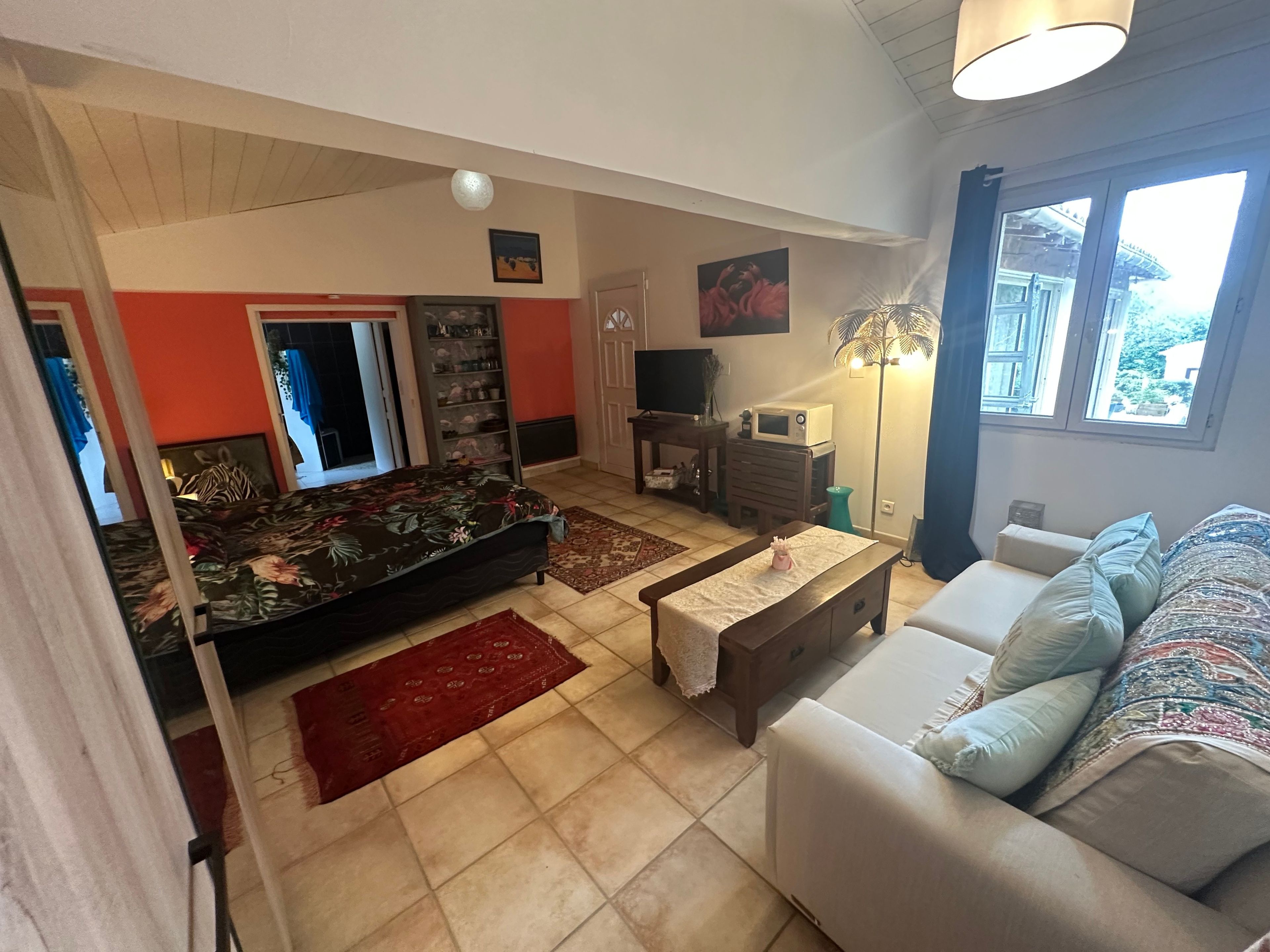 A living room with a sofa, a coffee table, a TV, and a lamp.