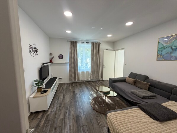 Una sala moderna con un sofá, un televisor y una decoración de pared con temática de café.