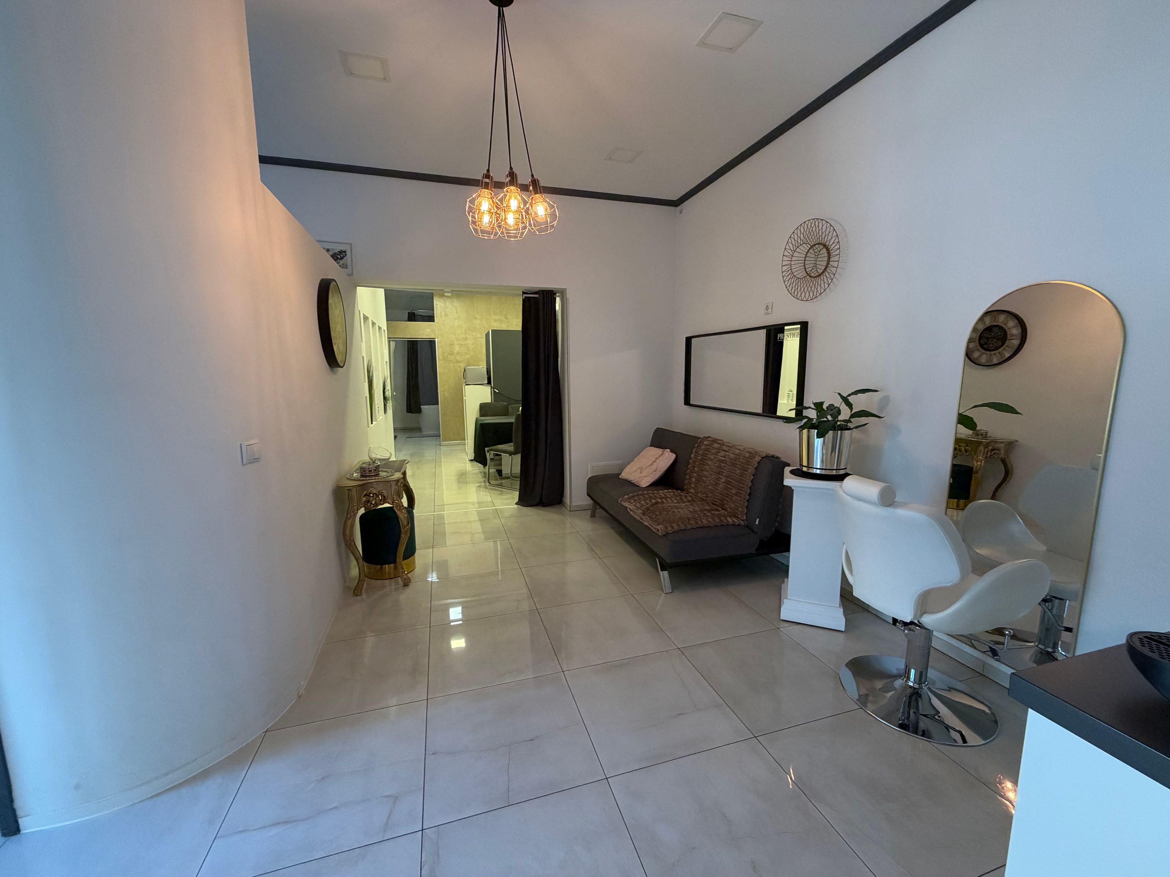 A modern living room with a sofa, a coffee table, and a dining area with chairs.