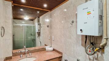 Een moderne badkamer met een douche, een wastafel met spiegel en een wandradiator.