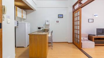A compact kitchen with a wooden island, a refrigerator, and a sink.