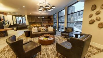 A modern living room with leather sofas, a coffee table, and a fireplace.