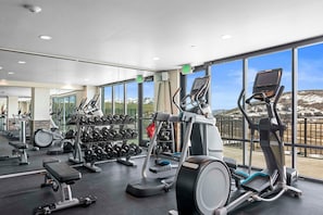A gym with various exercise equipment, large windows, and a view of snow-capped mountains. - Penthouse Suite with Deck, Private Bar & Views (Heber City)